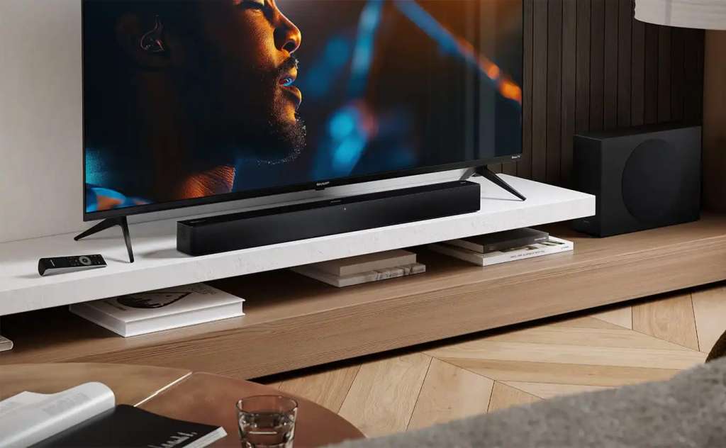 Telewizor Sharp Mini LED w towarzystwie soundbara na półce w salonie