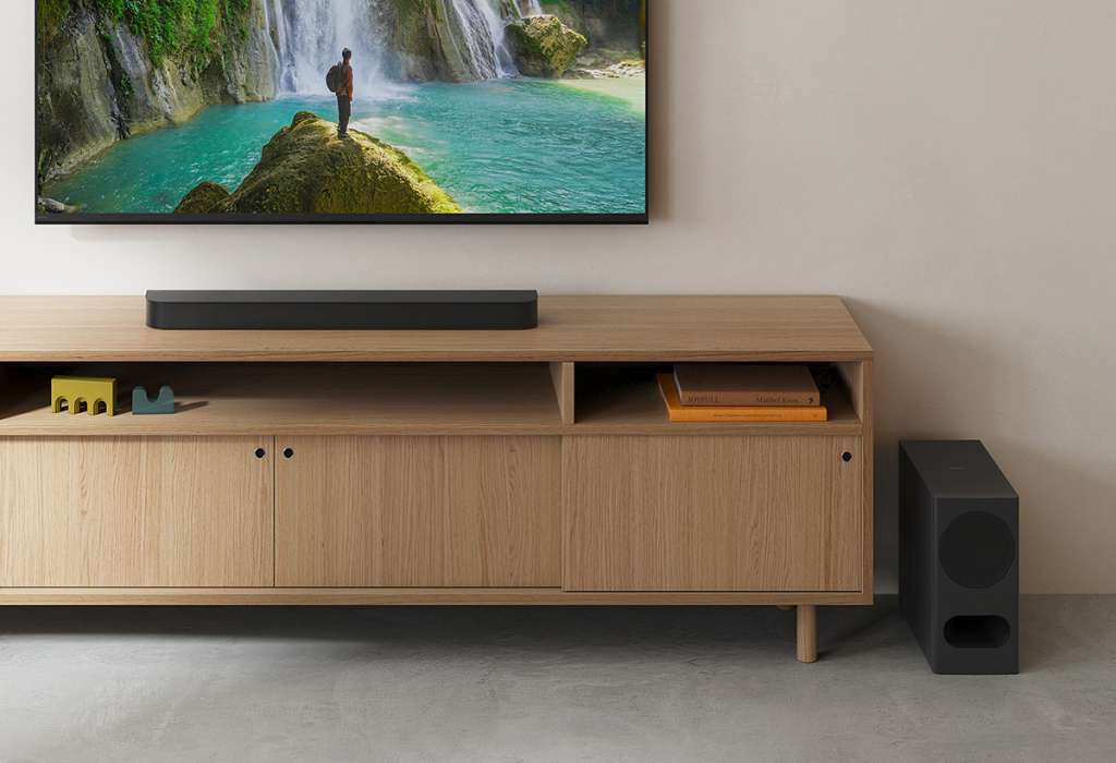Soundbar Sony BRAVIA Theatre Bar 5 na szafce RTV w salonie, powyżej wiszący telewizor
