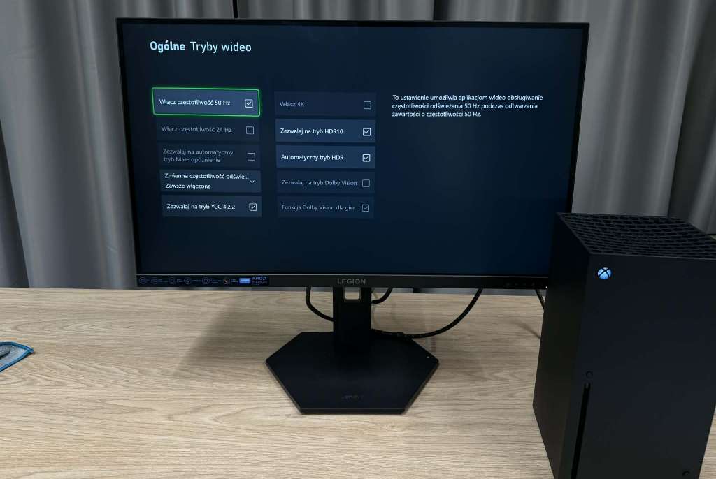 Monitor Lenovo Legion 27Q-10 na biurku podczas testu, na ekranie ustawienia konsoli Xbox
