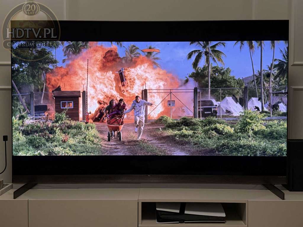 Telewizor TCL X11L wyświetlający dynamiczną scenę filmową z jasnym wybuchem, pokazującą możliwości HDR i wysoką jasność ekranu