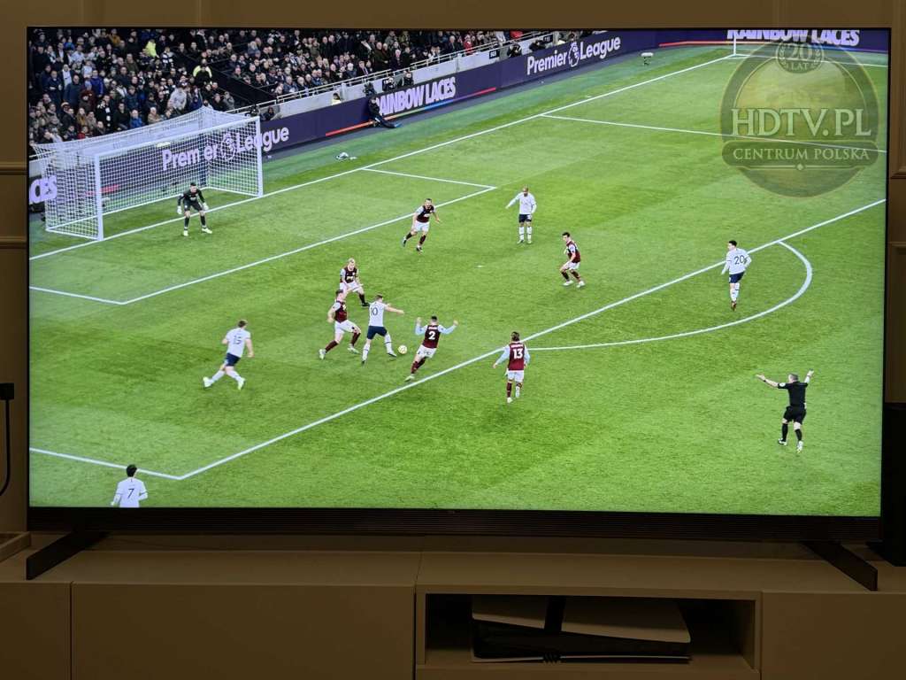 Telewizor TCL X11L wyświetlający mecz piłki nożnej na dużym ekranie w jasnym salonie