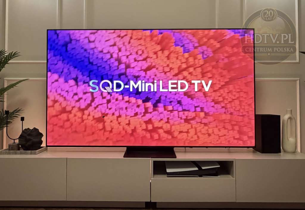 Telewizor TCL C7L stojący na szafce RTV, wyświetlający kolorową, trójwymiarową grafikę z napisem SQD-Mini LED TV podczas testu HDTVPolska