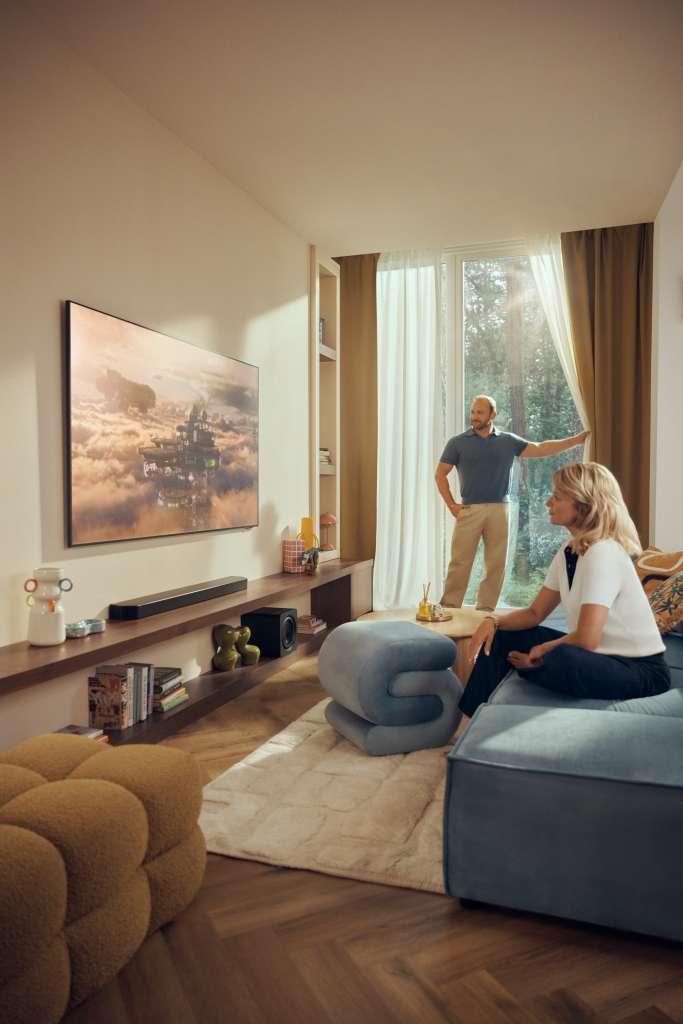 Bory i Anna Szyc ambasadorami marki Samsung - scena w salonie z telewizorem na ścianie i zasłoną okna